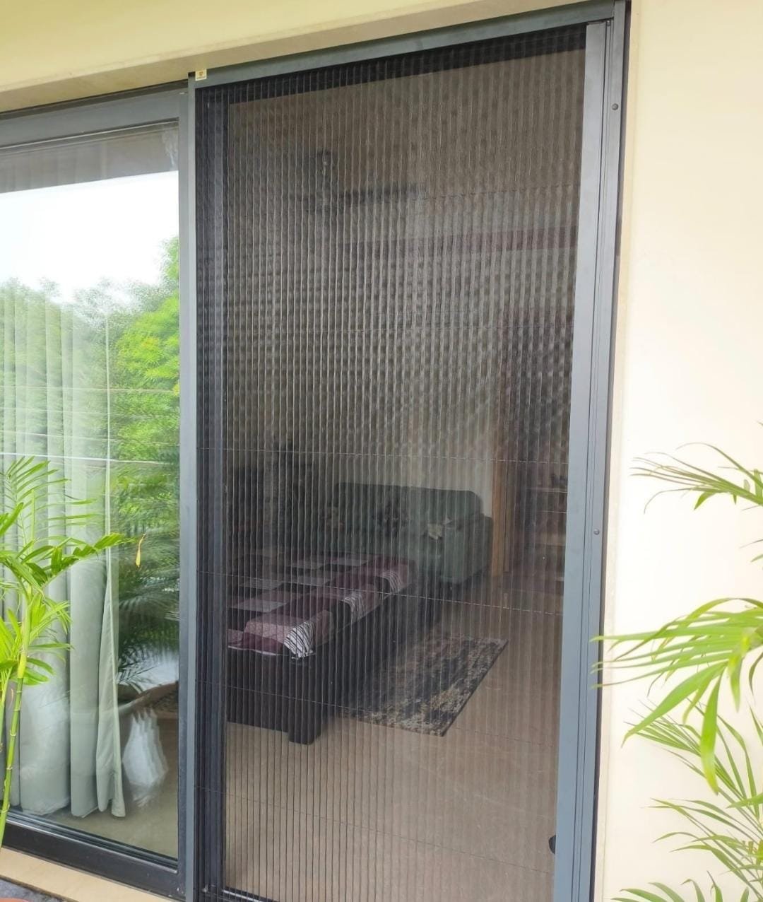 Pleated mosquito net door installed on a bedroom sliding window